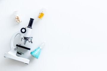 Do medical research with microscope, pills in test-tubes in lab on white background top view mock-up