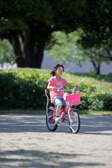 夏の公園で自転車を乗っている子供