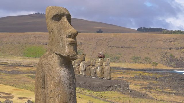 DRONE COPY SPACE: Stunning shot of a mysterious ancient monoliths shaped as humans. Flying around a legendary moai statue on a remote island in Chile. Scenic national park full of intriguing megaliths
