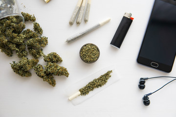 Cannabis buds on black table, close up, joint with weed, grinder in hand with fresh marijuana,