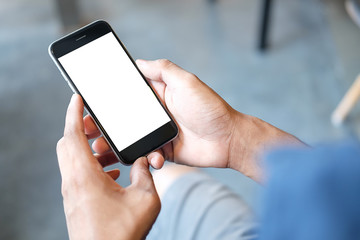 Cropped shot view of man hands holding smart phone with blank copy space screen for your text message or information content, female reading text message on cell telephone during in urban setting. 