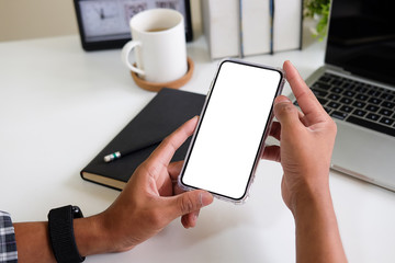 Cropped shot view of man hands holding smart phone with blank copy space screen for your text message or information content, female reading text message on cell telephone during in urban setting. 