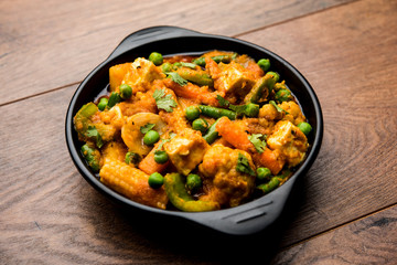 Mix vegetable curry - Indian main course recipe contains Carrots, cauliflower, green peas and beans, baby corn, capsicum and paneer/cottage cheese with traditional masala and curry, selective focus