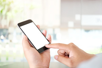 Cropped shot view of man hands holding smart phone with blank copy space screen for your text message or information content, female reading text message on cell telephone during in urban setting.
