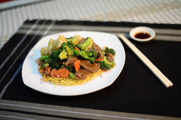 Asian cuisine, close up of a fried noodle dish on a table, ready to eat