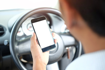 Cropped shot view The driver uses the phone while driving. Modern smart phone with round edges. Isolated screen for mockup. Car navigation display in background.