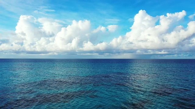 loopable background shot of open ocean Great Barrier Reef Coral Pacific Ocean Queensland Australia, bright blue sky with fluffy clouds