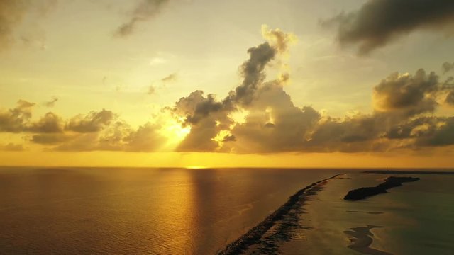 sun behind the clouds, golden sunset over Barbados coral reefs, dramatic sky over Atlantic ocean, dramatic sky with fluffy clouds