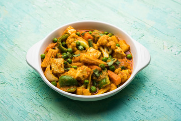 Mix vegetable curry - Indian main course recipe contains Carrots, cauliflower, green peas and beans, baby corn, capsicum and paneer/cottage cheese with traditional masala and curry, selective focus