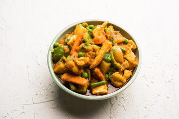 Mix vegetable curry - Indian main course recipe contains Carrots, cauliflower, green peas and beans, baby corn, capsicum and paneer/cottage cheese with traditional masala and curry, selective focus