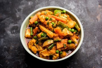 Mix vegetable curry - Indian main course recipe contains Carrots, cauliflower, green peas and beans, baby corn, capsicum and paneer/cottage cheese with traditional masala and curry, selective focus