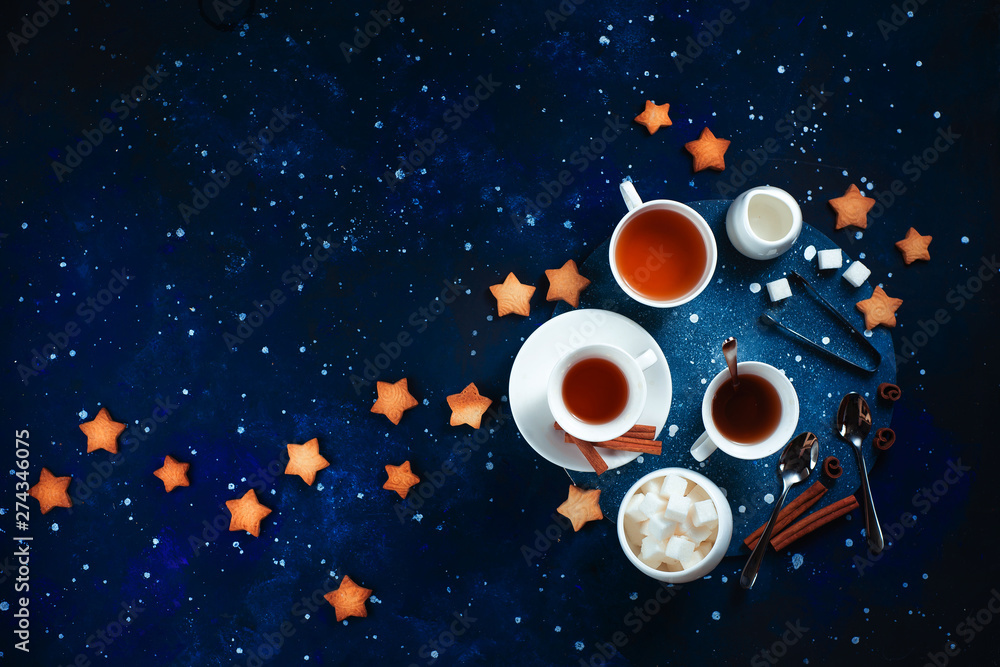 Wall mural teatime with star-shaped cookies. white porcelain cups on a starry sky background. astronomy and con
