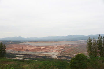 Lignite coal mining industry as a raw materials for coal fire electric power plant. There are excavators and transport trucks are working within the lignite coal mine.