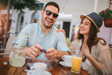 Beautiful loving couple sitting in a cafe enjoying in coffee and conversation