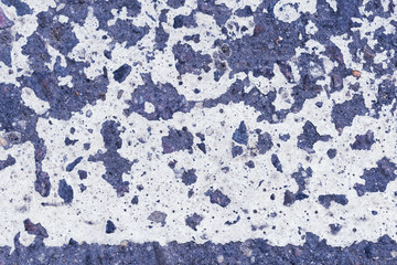 White paint on the old asphalt surface close up. Blue color abstract background