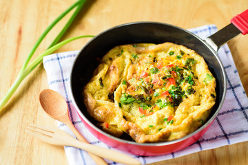 Omelette with spring onion in a pan