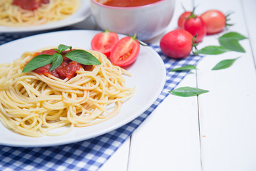 Spaghetti pasta with and tomato sauce on wood background