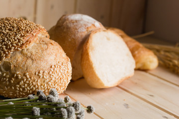 bread and wheat on white wood background with copy space