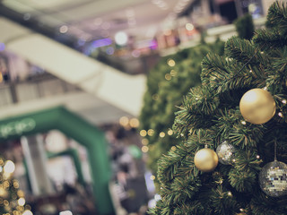 bauble hanging from a decorated Christmas tree. Retro filter effect