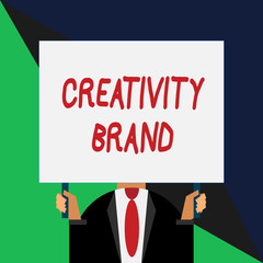 Conceptual hand writing showing Creativity Brand. Concept meaning design name or feature that distinguishes organization Just man chest dark suit tie no face holding blank rectangle