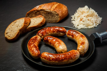 Fototapeta premium appetizing ruddy meat wieners fried in large frying pan