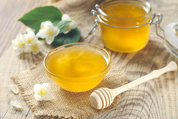 fragrant golden honey in a glass jar on a wooden table