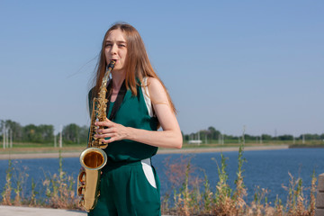 Young woman with saxophone in the park