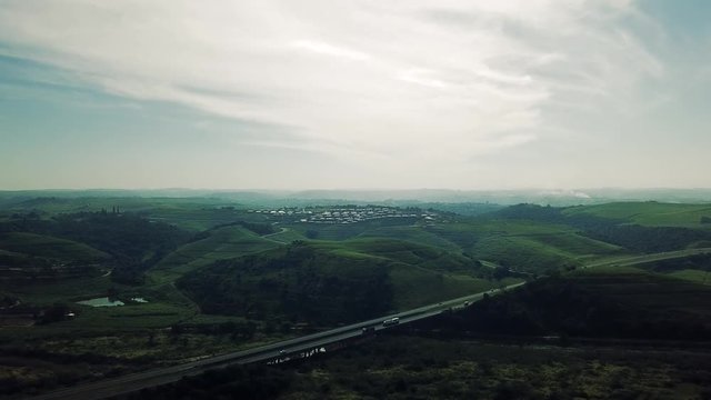Aerial footage filmed by a Drone of Scottburgh Beach and Land grassy fields with residential houses overlooking the sea in Kwa Zulu Natal South Africa