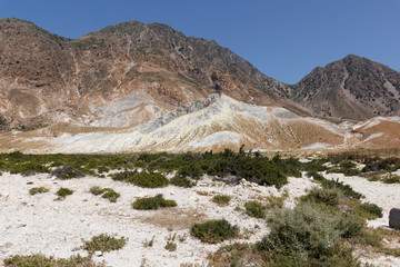 view of the Caldera of the volcano on Nisyros, a huge crater with snow-white sediments, sulfur crystals, from a height, the landscape around resembles a desert