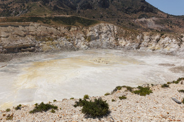 view of the Caldera of the volcano on Nisyros, a huge crater with snow-white sediments, sulfur crystals, from a height, the landscape around resembles a desert