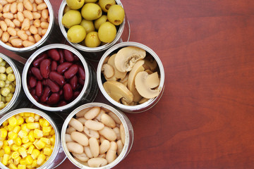 Canned food in tin cans on wooden table 