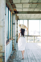 Summer image and light dress. Portraits of a beautiful girl at sunset in an abandoned building.