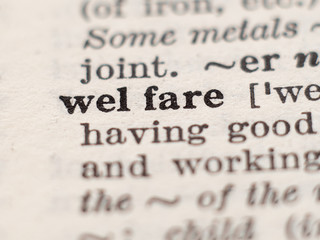 Dictionary definition of word welfare, selective focus.