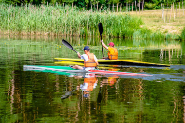 Two men floating in a canoe on the river