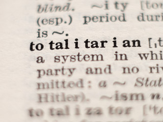 Dictionary definition of word totalitarian, selective focus.