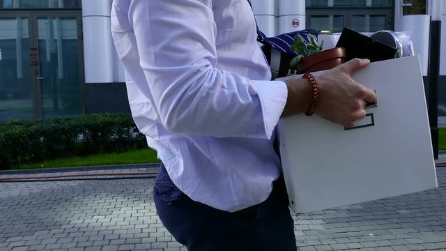 A man carries a large box with things from the office