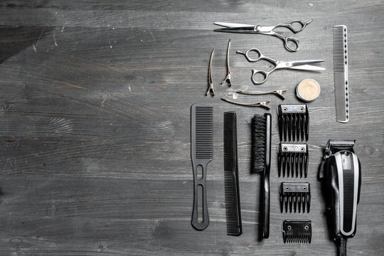 Set of professional hairdresser tools on grey background. Wooden table in barbershop. Working tool of barber master