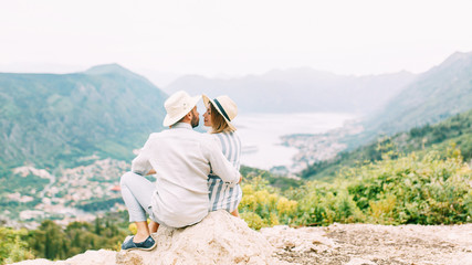 Naklejka premium Summer photo shoot at sunset in the Bay of Kotor. Wedding love story with a beautiful couple.