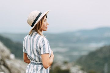 Summer photo shoot at sunset in Kotor, Montenegro. A beautiful girl in a blue dress and hat.
