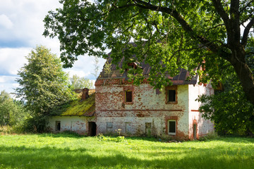 Collapsing two-story brick house in the park on a summer day