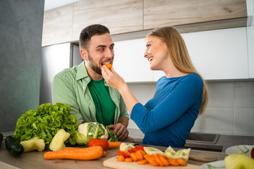 Young couple is preparing meal in their kitchen. 