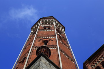 Campanile di una chiesa con cielo azzurro a Milano