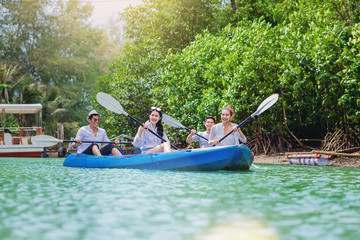 Fototapeta na wymiar Cheerful happiness friends kayaking in the Lagoon on summer vacation holiday