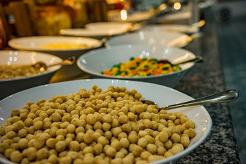On the table for dinner plates with ingredients to the dish. Peas, sauce, jam.