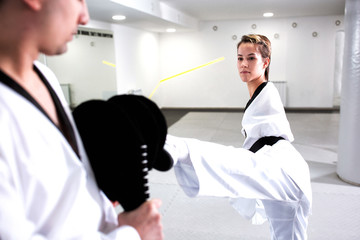 Fototapeta premium Young cute girl with physical disability focused on kicking technique