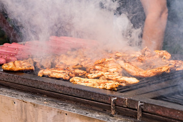 Meat is fried on the grill on the coals. Cook roasts meat on the coals.