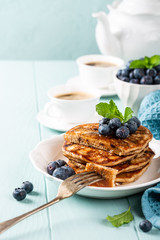 Delicious pancakes with chocolate drops, honey and blueberries. Healthy breakfast concept with copy space.