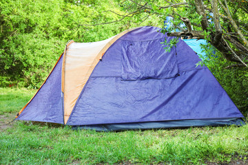 Camping tent in forest on summer day