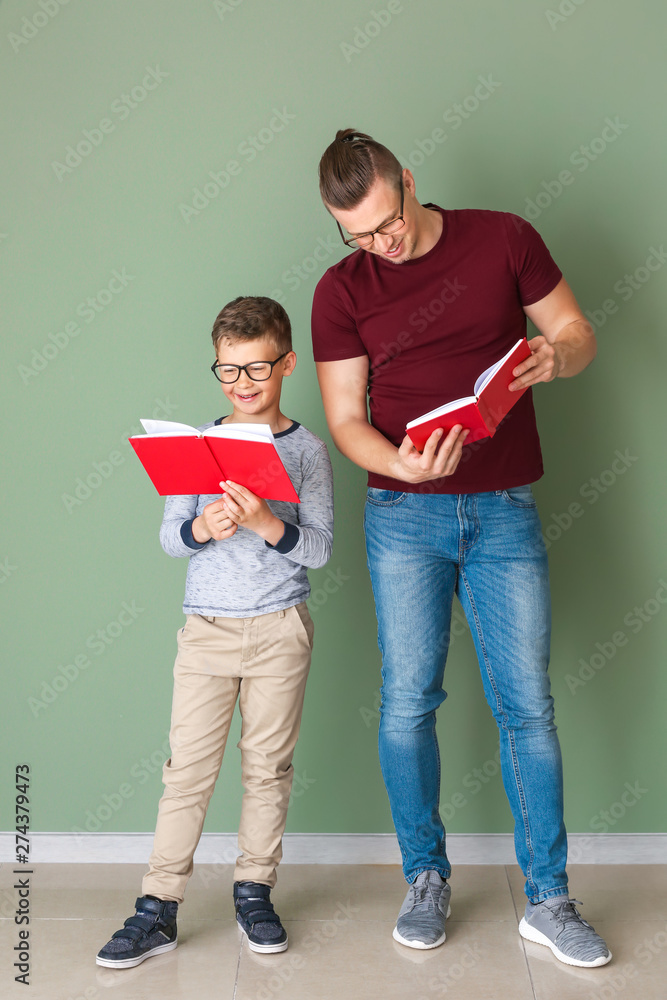 Poster Portrait of father and son with books near color wall