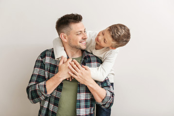 Happy man with little adopted boy on white background